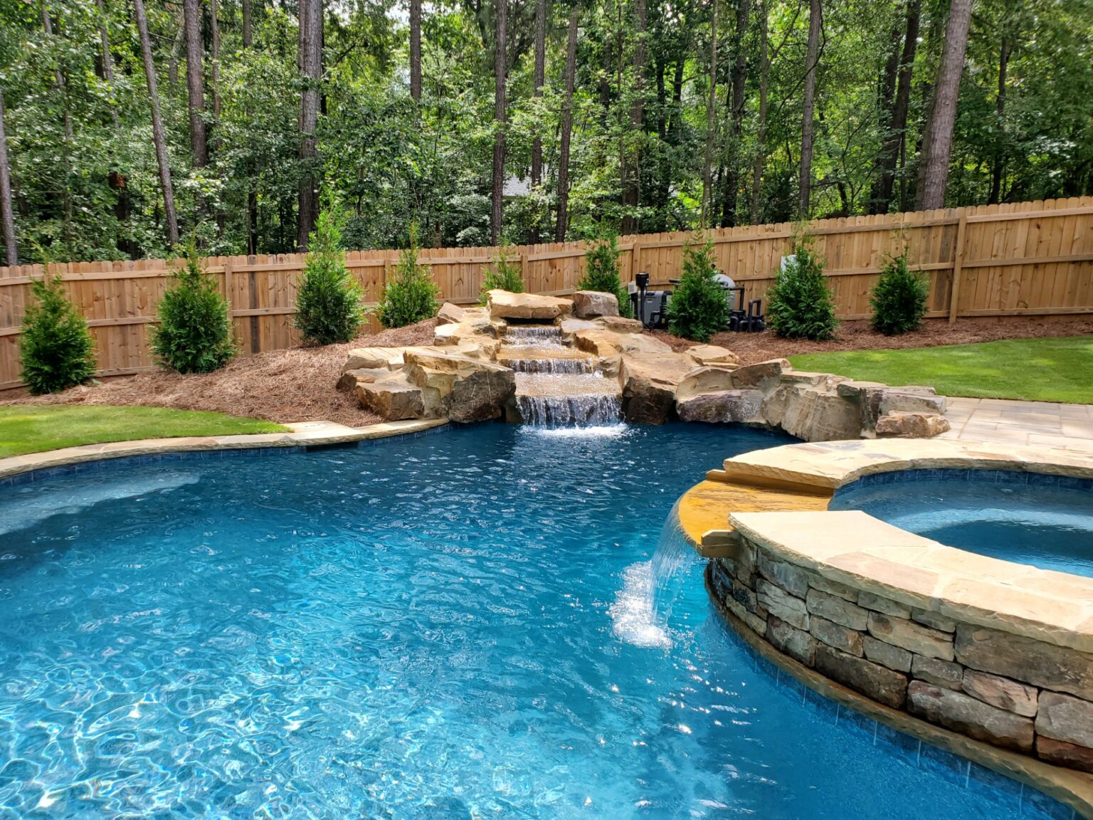 Outdoor oasis in Lawrenceille, Georgia, with custom boulders walls, waterfall.