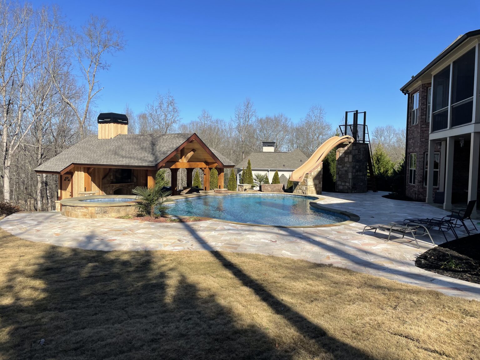 Custom swimming pool with cedar open air cabana, fireplace, and kitchen.